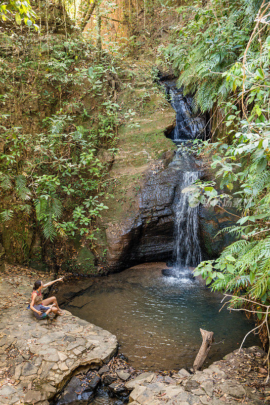 母子轻松地坐着瀑布Pirenópolis Goiás